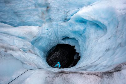 Climbing out of a moulin on our summer ice climbing tour in Valdez.