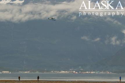 A Piper PA-14 flies over Port Valdez.